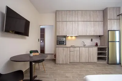 a kitchen with a table and a refrigerator at Oleana di Castello in Rhodes Town