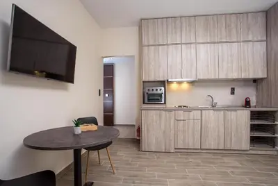 a kitchen with wooden cabinets and a table in a room at Oleana di Castello in Rhodes Town