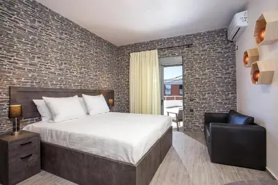 a bedroom with a bed and a brick wall at Oleana di Castello in Rhodes Town