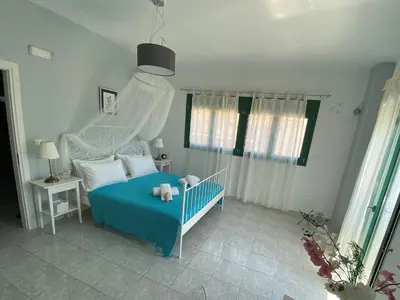 a bedroom with a blue bed with a white canopy at Paraskevi's Apt - City Center w/ Lovely Park View in Rhodes Town