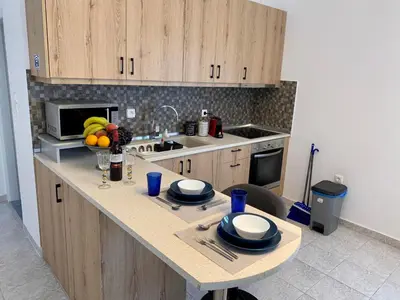 a kitchen with a table with a bowl of fruit on it at Paraskevi's Apt - City Center w/ Lovely Park View in Rhodes Town