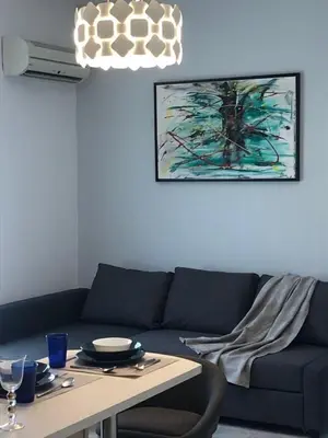 a living room with a blue couch and a table at Paraskevi's Apt - City Center w/ Lovely Park View in Rhodes Town