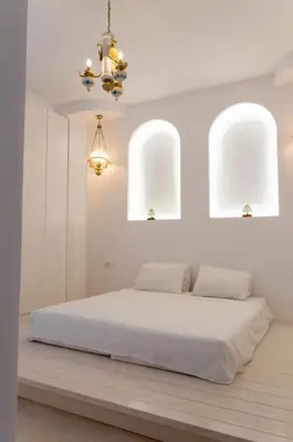 a white bedroom with a bed and two windows at Villa Iliousa Grand in Psinthos