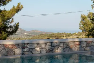 a stone wall with a view of a mountain at Villa Iliousa Grand in Psinthos