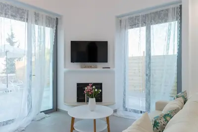 a living room with a couch and a table with flowers at Villa Iliousa Grand in Psinthos