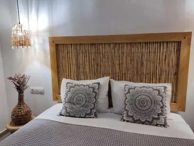 a bedroom with a bed with a wooden headboard and pillows at Callas Residence in Triánta
