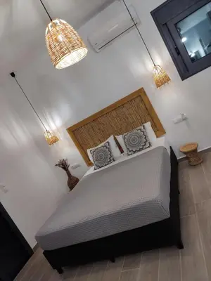 a bedroom with a bed and a mirror and a chandelier at Callas Residence in Triánta
