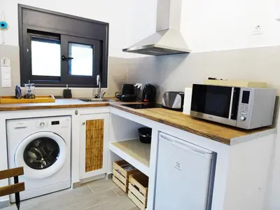 a kitchen with a washing machine and a microwave at Callas Residence in Triánta