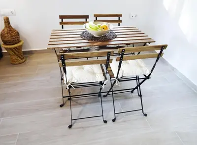 a wooden table with two chairs and a bowl of fruit at Callas Residence in Triánta