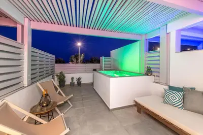 a patio with a pool table and chairs at Kellys Luxury Apartments in Faliraki