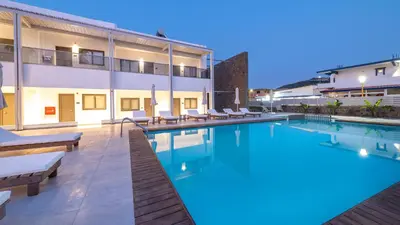 a swimming pool with chairs and a building at Kellys Luxury Apartments in Faliraki