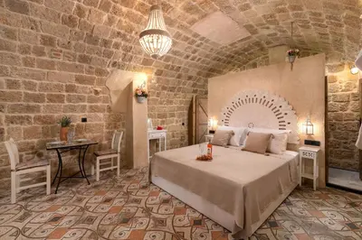 a bedroom with a large bed in a brick wall at Stone Cave Suite in Rhodes Town