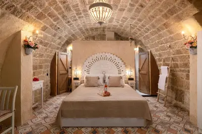 a bedroom with a large bed in a stone wall at Stone Cave Suite in Rhodes Town
