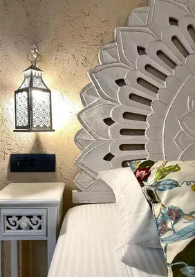 a bed with a metal headboard next to a side table at Stone Cave Suite in Rhodes Town