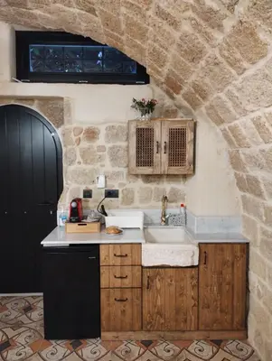a kitchen with a sink and a stone wall at Stone Cave Suite in Rhodes Town