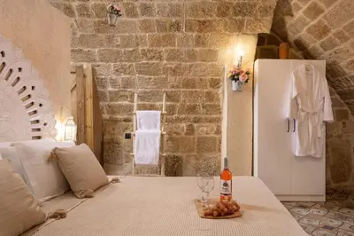 a room with a table with a bottle of wine and a refrigerator at Stone Cave Suite in Rhodes Town