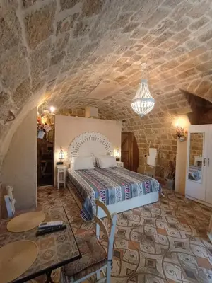 a bedroom with a bed and a stone wall at Stone Cave Suite in Rhodes Town