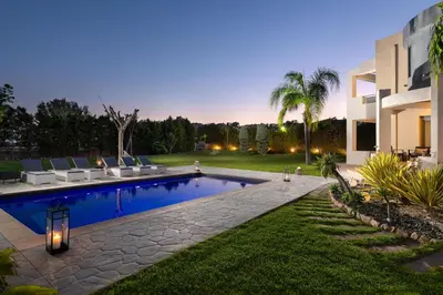 a backyard with a swimming pool and a house at Villa Rapha Maris in Afantou