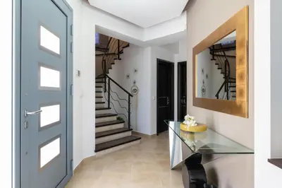 a hallway with a glass table and stairs at Villa Rapha Maris in Afantou