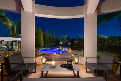 a patio with two chairs and a table and a pool at Villa Rapha Maris in Afantou