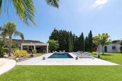 a swimming pool in a yard with lounge chairs at Villa Rapha Maris in Afantou