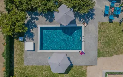 an overhead view of a swimming pool with umbrellas at The Green Beauty in Pastida