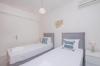 two beds in a room with white walls at The Green Beauty in Pastida