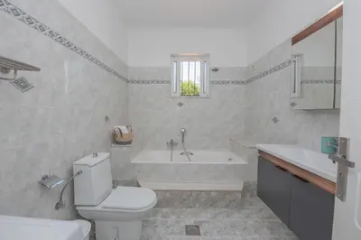 a bathroom with a toilet and a tub and a sink at The Green Beauty in Pastida
