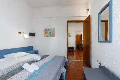 a hotel room with a bed and a mirror at Emmanuel Apartments in Rhodes Town