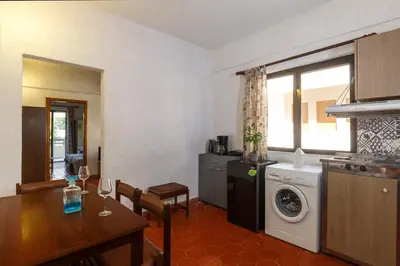 a kitchen and dining room with a table and a washing machine at Emmanuel Apartments in Rhodes Town