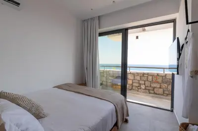 a bedroom with a bed and a view of the ocean at Villa Auretta in Pefki Rhodes