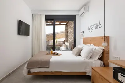 a bedroom with a bed with white sheets and pillows at Villa Auretta in Pefki Rhodes