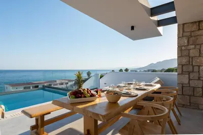 a dining room with a table and chairs and a pool at Villa Auretta in Pefki Rhodes
