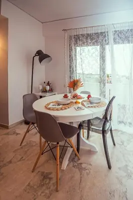 a dining room table with chairs and a white table and a window at Loft style apartment near the Old Town in Rhodes Town
