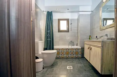 a bathroom with a tub and a toilet and a sink at Loft style apartment near the Old Town in Rhodes Town
