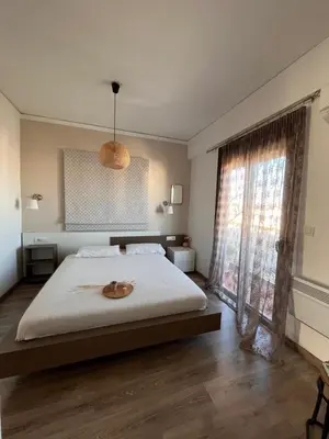 a bedroom with a bed and a large window at Loft style apartment near the Old Town in Rhodes Town
