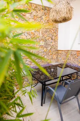 a table and a chair in front of a stone wall at City Compass Luxury Suites in Rhodes Town