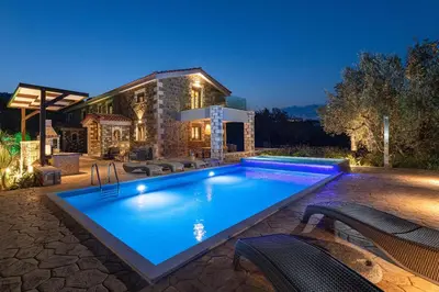 a swimming pool in front of a house at Villa Antheia in Kalathos