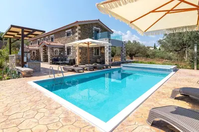 a swimming pool in front of a house at Villa Antheia in Kalathos
