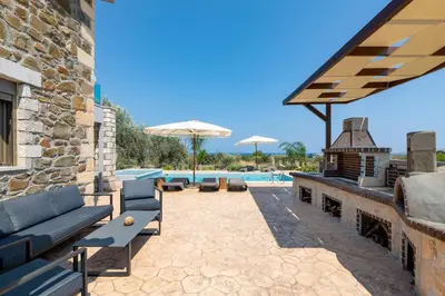 a patio with two couches and a swimming pool at Villa Antheia in Kalathos