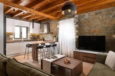 a living room with a couch and a table and a kitchen at Villa Antheia in Kalathos