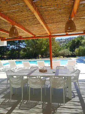 a table and chairs on a patio with a pool at Chrysanthi Villa, Living in Nature in vlicha