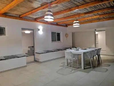 a dining room with a table and chairs and a couch at Chrysanthi Villa, Living in Nature in vlicha