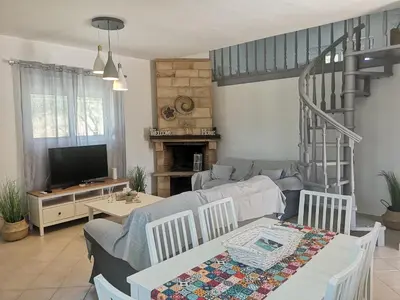a living room with a couch and a table at Chrysanthi Villa, Living in Nature in vlicha