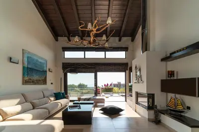 a living room with a couch and a chandelier at Ethereum Villa in Asgourou