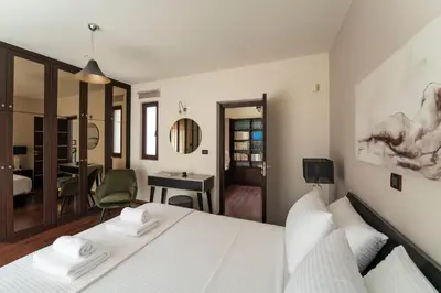 a bedroom with a white bed and a desk at Ethereum Villa in Asgourou