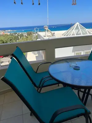 a table and chairs on a balcony with a view of the ocean at Karakonero view apartment in Rhodes Town