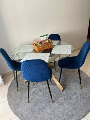 a glass table with four chairs and a basket of fruit at Karakonero view apartment in Rhodes Town