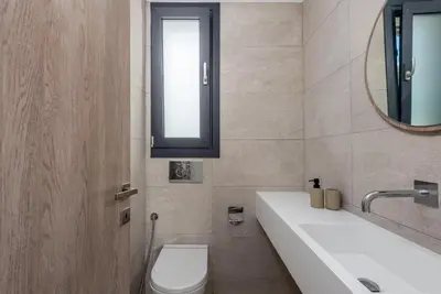 a bathroom with a sink and a toilet and a mirror at Lindian Palms in Lardos