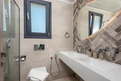 a bathroom with a sink and a glass shower at Lindian Palms in Lardos